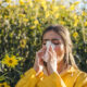 Portrait of a young woman surrounded by flowers and developing an allergic reaction
