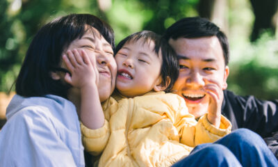 Happy Japanese family smiling in a park in Tokyo with their baby