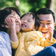 Happy Japanese family smiling in a park in Tokyo with their baby