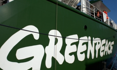 A close-up of the Greenpeace logo on their ship which is called the Rainbow Warrior III